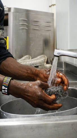 Picture of man washing hands in the community kitchen